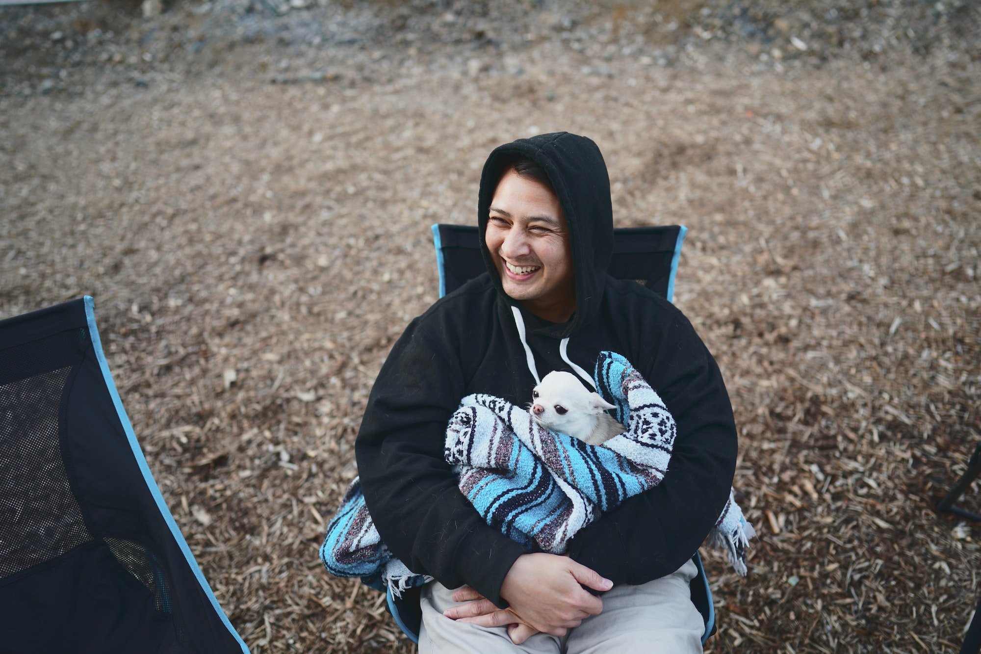 Guy camping with dog in a blanket