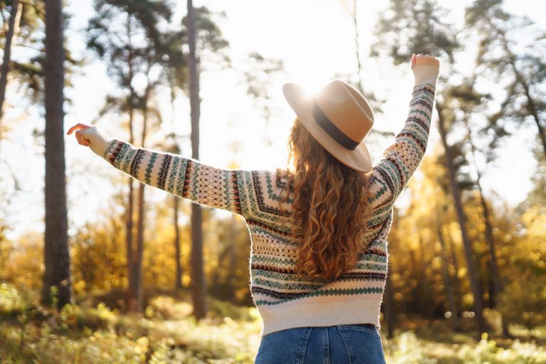 Outdoor atmospheric lifestyle. portrait of beautiful woman having fun in autumn forest. Warm autumn