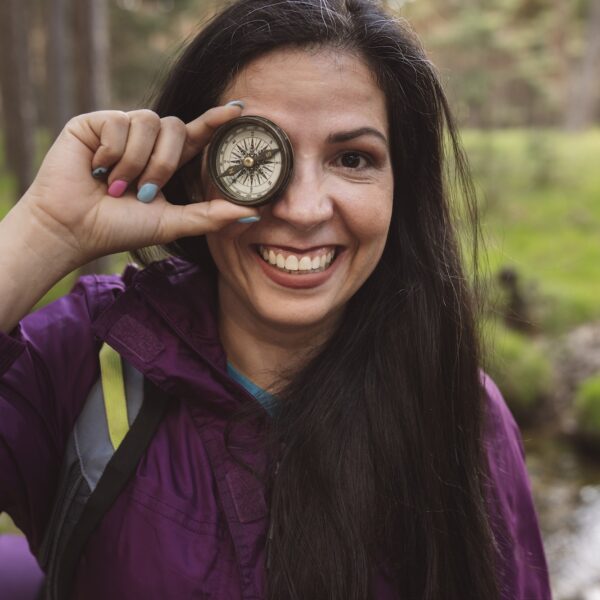 mature woman backpacker with a compass smiling